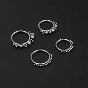 Detailed view of silver 316L stainless steel hinged nose rings with white cubic zirconia