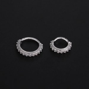 Detail of two silver hinged hoop rings in different sizes with cubic zirconia inlay