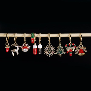 Detailed macro view of colorful Christmas themed enamel charms hanging on a wooden rod