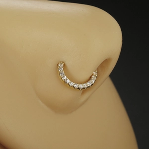Detailed view of a gold nose ring with pave-set zircons on a silicone display model