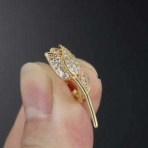 Boucle d'oreille tulipe dorée avec incrustation de zircon blanc en vue macro