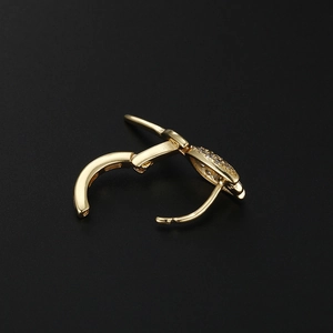 Gros plan d'une boucle d'oreille créole rose en zircon doré avec fermoir à loquet