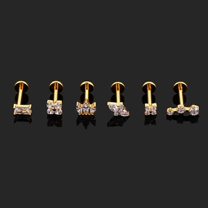 Detailed macro view of gold-plated labret studs with cubic zirconia in assorted shapes