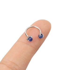 Macro shot of 316L stainless steel horseshoe ring with claw-set blue cat eye stones