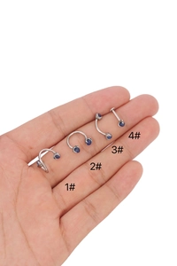 Macro shot of four 316L stainless steel labret studs with dark blue opal stone settings