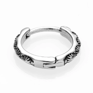 Close-up of vintage stainless steel hoop earring with engraved sunburst relief pattern