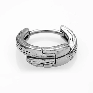 Detail of vintage stainless steel earring with unique wood grain texture and hinged clasp