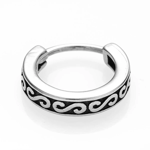 Detail of vintage steel hoop earring featuring intricate floral scroll engraving and dark patina