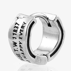 Macro shot of silver stainless steel leaf huggie earring with black engraving and vintage finish