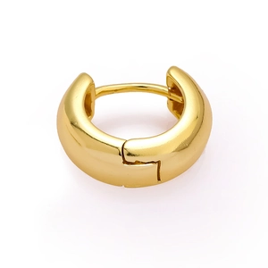 Detailed close-up of polished gold huggie hoop earring with secure snap closure
