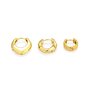 Detailed macro of golden geometric copper hoop earrings with polished and textured finishes