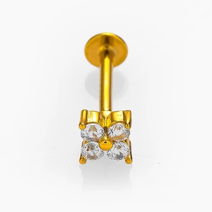 Vista macro di piercing labret in acciaio 316L dorato con trifoglio e zirconi intarsiati