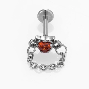 Vue macro du piercing en zircon orange en forme de cœur avec une petite chaîne