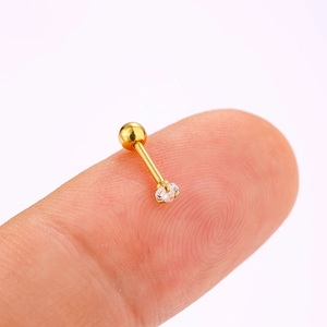 Detailed macro view of gold-plated stainless steel stud earring with a 4-prong zircon on finger