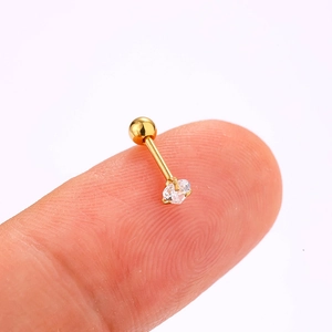 Macro shot of 316L gold steel piercing stud with heart-shaped zircon on a fingertip