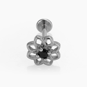 Detalle de joya de piercing con diseño de pétalo hueco y una piedra de circón negro