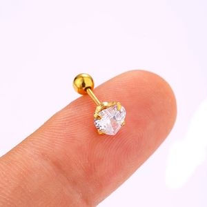 Macro shot of a heart-shaped zircon stud earring with a 4-claw setting on a fingertip