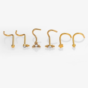 Macro shot of 6-piece golden nose stud set with cubic zirconia shapes and smooth balls