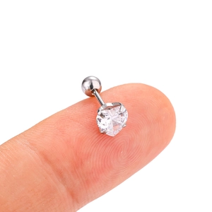 Macro view of a tiny heart-shaped zircon stud earring held between fingers for scale
