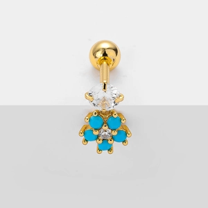 Macro detail of gold flower piercing stud with blue stones and clear cubic zirconia