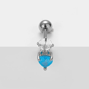Macro shot of curved stainless steel navel bar with round zircon and blue heart gem