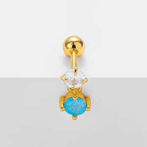 Detailed view of a gold-plated navel ring featuring clear crystal and blue stone inlay