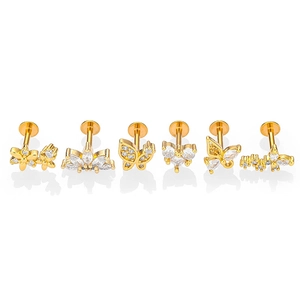 Détail d'un lot de six piercings labret dorés avec motifs papillon et fleur en zircon