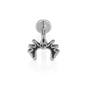 Detalle del piercing labret de acero 316L con diseño de calavera punk negra