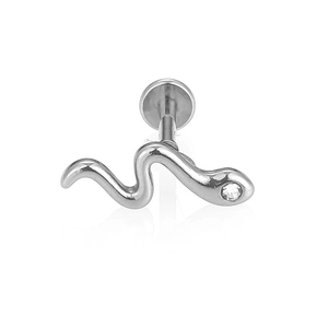 Primer plano detallado de un piercing labret de serpiente plateada con circón claro
