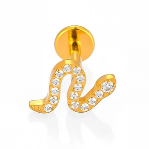 Detailed macro view of gold-plated titanium labret stud with crystal N-letter design