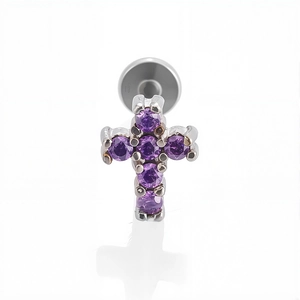 Dettaglio macro del piercing a croce in acciaio 316L con zirconi viola