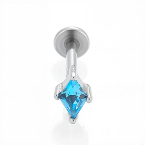 Dettaglio macro del labret in acciaio 316L con zircone blu a rombo incastonato a 4 griffe