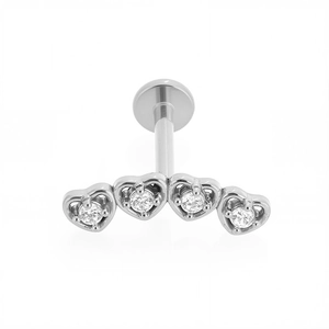 Detalle de cuatro piercings labret de acero 316L en forma de corazón con piedras de circón
