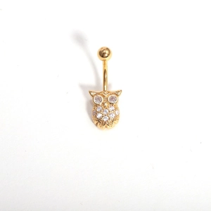 Detailed view of a golden owl navel ring inlaid with sparkling cubic zirconia stones