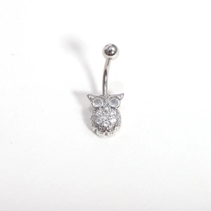 Macro detail of silver owl belly ring with shimmering zircon eyes and crystal body wings