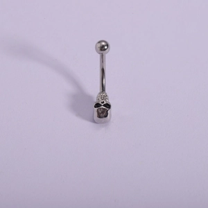 Macro detail of 316L stainless steel navel ring featuring a silver skull head design