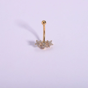 Detail of gold curved navel ring with three zircon flower charms on purple background