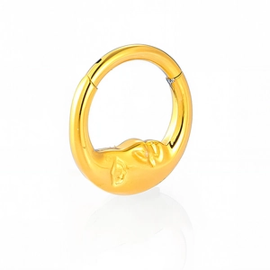 Close-up of golden 316L stainless steel nose ring with embossed moon face design