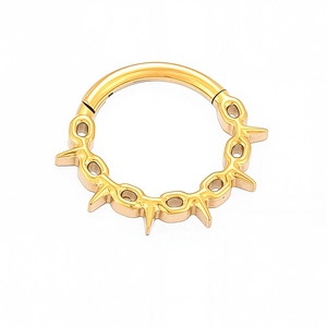 Detailed close-up of golden titanium nose ring with punk spikes and hollow accents