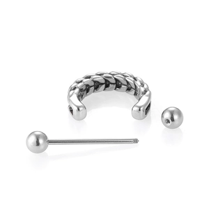 Gros plan sur l'anneau de nez tressé argenté et le piercing barbell métallique