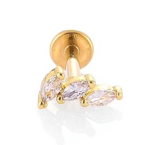 Gros plan d'un labret doré orné de trois zircons transparents en forme de marquise