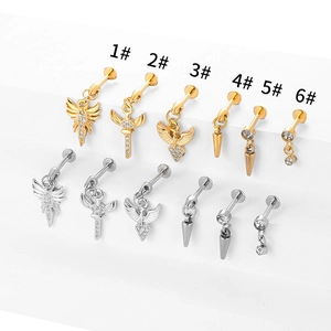 Detail showing 316L stainless steel lip and ear piercings with wing and cross charms