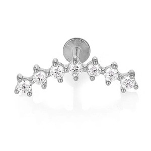 Close-up of a curved stainless steel labret stud with seven white zircons and flat back