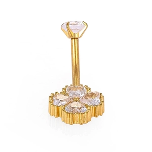 Détail macro du piercing nombril doré 316L avec trèfle et pierres de zircon en cœur