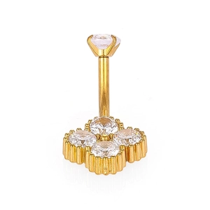 Détail macro d'un piercing nombril en or 316L avec un cluster de fleurs en zircon trèfle