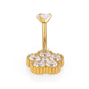 Détail d'un piercing de nombril fleur dorée en acier 316L avec des pierres de zircone
