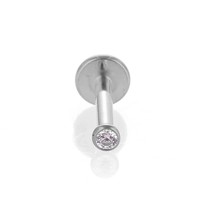 Vue macro d'un piercing labret en titane avec zircon rose serti clos et poli brillant