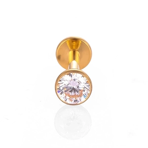 Détail d'un piercing labret doré avec zircone sertie clos et base plate lisse