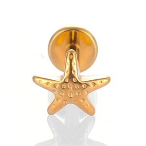 Macro view of gold titanium starfish piercing stud with textured dot surface detail
