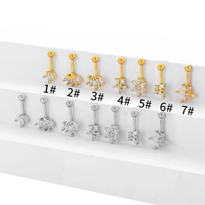 Detalle de piercings para cartílago con diseños de corona y flor con circonitas blancas